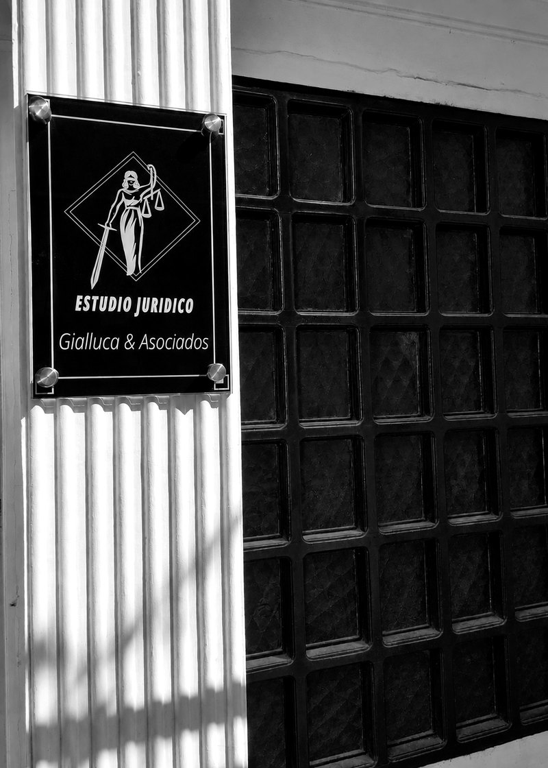 Placa del Estudio Jurídico Gialluca & Asociados en la entrada de Rivadavia 207